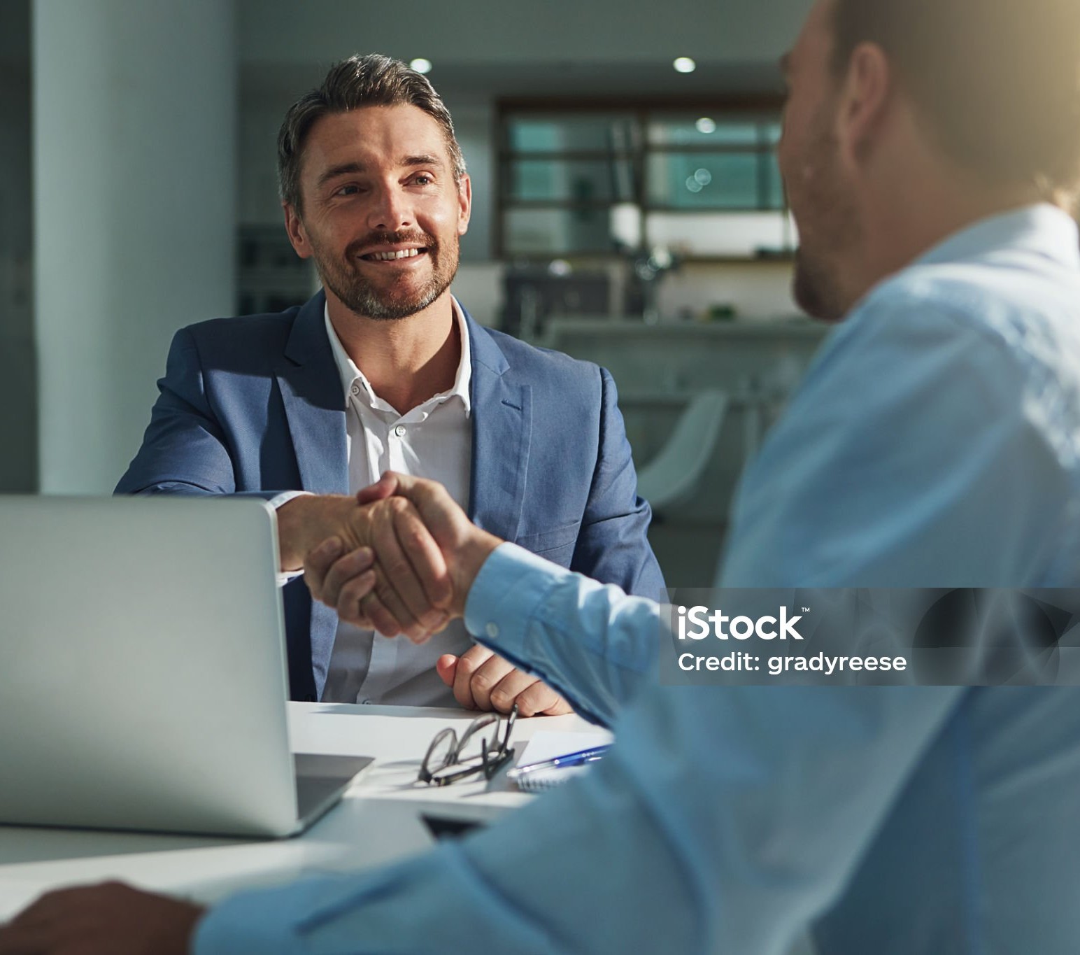 Shot of two businessmen shaking hands in an office